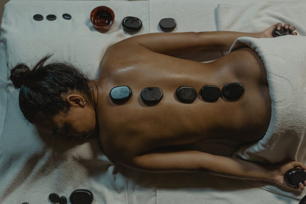 pexels-photo-6187657 A serene spa scene with hot stone massage therapy focusing on health and relaxation.